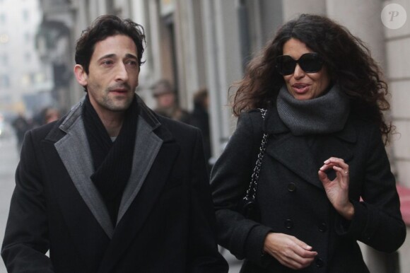 Très concentrés, Adrien Brody et Afef Jnifen discutent dans la rue à Milan le 19 janvier 2012