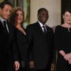 Carla Bruni-Sarkozy et Nicolas Sarkozy posent devant le seuil du palais présidentiel de l'Elysée avec Alassane  Ouattara, président ivoirien, et son épouse Dominique Ouattara, le 26 janvier 2012, à l'occasion d'un dîner d'Etat