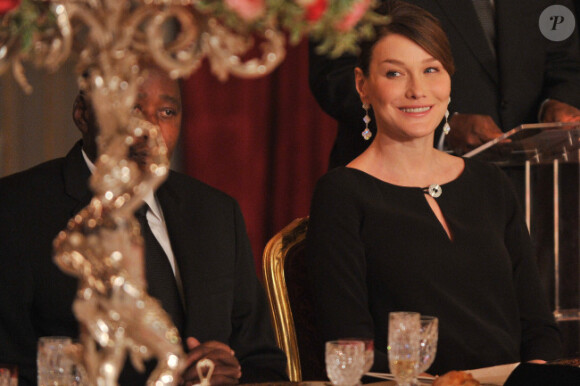 Carla Bruni-Sarkozy, ravissante, et Nicolas Sarkozy reçoivent le  président ivoirien Alassane Ouattara et  son épouse Dominique Ouattara, le 26 janvier 2012, à l'occasion d'un  dîner d'Etat