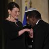 Carla Bruni-Sarkozy et Nicolas Sarkozy posent devant le seuil du palais présidentiel de l'Elysée avec Alassane Ouattara, président ivoirien, et son épouse Dominique Ouattara, le 26 janvier 2012, à l'occasion d'un dîner d'Etat