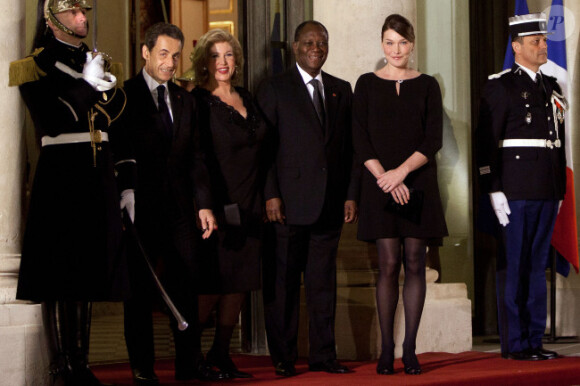Carla Bruni-Sarkozy et Nicolas Sarkozy posent devant le seuil du palais présidentiel de l'Elysée avec Alassane  Ouattara, président ivoirien, et son épouse Dominique Ouattara, le 26 janvier 2012, à l'occasion d'un dîner d'Etat