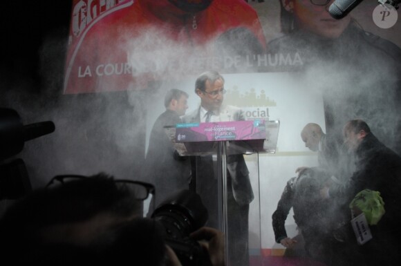 François Hollande se fait enfariné par Claire Seguin le 1er février 2012 à la Porte de Versailles lors de la présentation du rapport annuel sur le mal-logement de la Fondation Abbé Pierre.