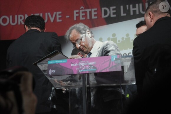 François Hollande se fait enfariné par Claire Seguin le 1er février 2012 à la Porte de Versailles lors de la présentation du rapport annuel sur le mal-logement de la Fondation Abbé Pierre.