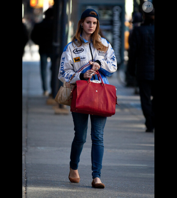 Lana Del Rey de retour à New York change complètement de style. Fini les looks rétro chic, elle préfère une veste de Formule 1 à New York le 3 février 2012. 
