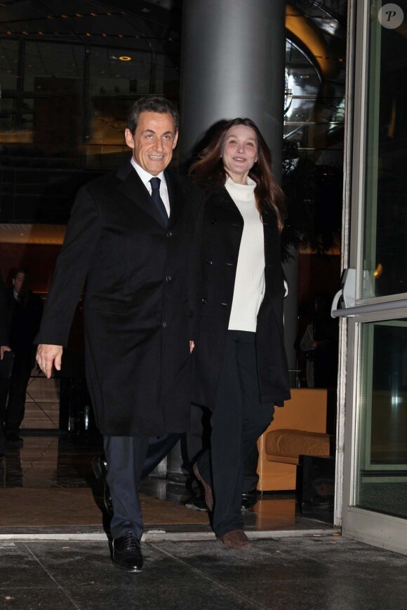 Nicolas Sarkozy, souriant et décidé, et Carla Bruni arrivent dans les locaux de TF1 juste avant sa déclaration au journal télévisé de 20 heures de Laurence Ferrari, à Paris, le 15 février 2012.