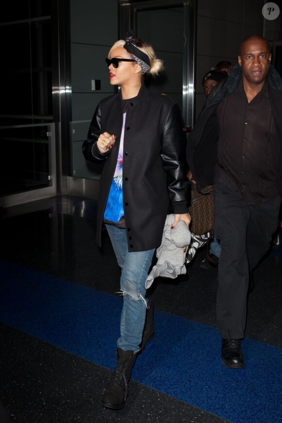 Rihanna, habillée d'une veste bomber et d'un t-shirt Givenchy, d'un jean et de bottes Alexander Wang, arrive à l'aéroport JFK à New York. Le 18 mars 2012.