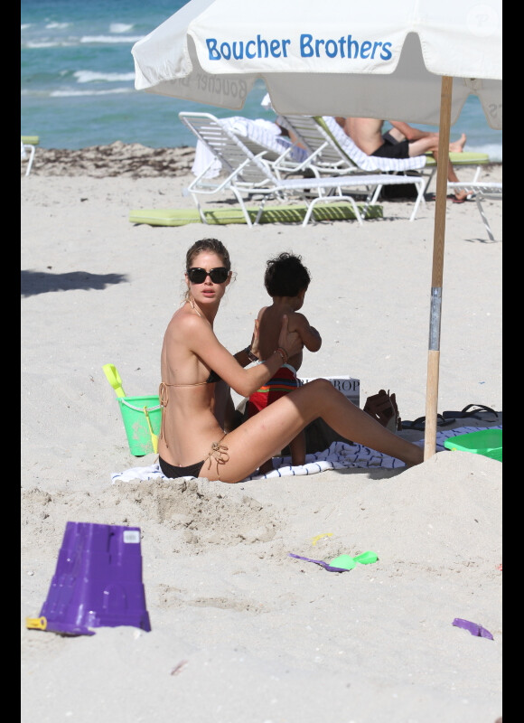 Doutzen Kroes et son fils Phyllon Joy à l'ombre sur la plage, le 23 mars 2012 à Miami
