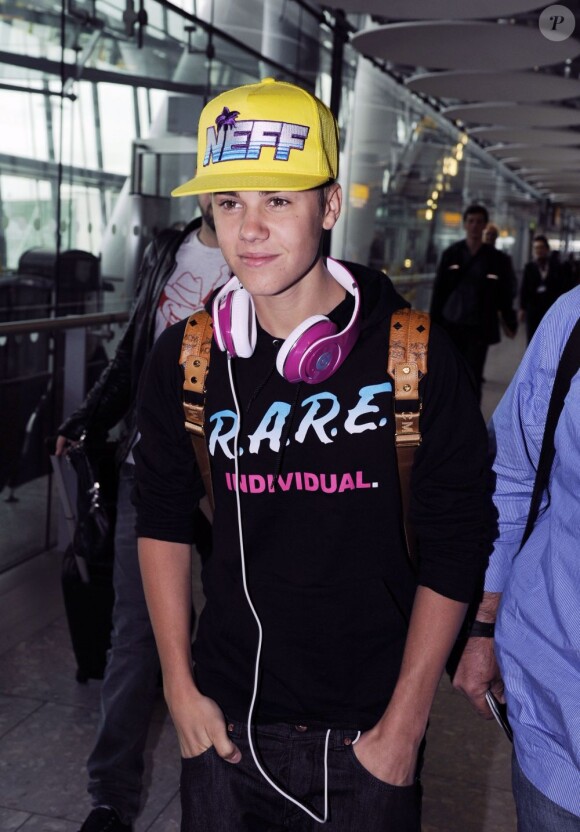 Justin Bieber arrive avec le sourire à l'aéroport d'Heathrow à Londres, le 23 avril 2012.
