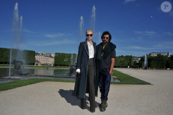 L'actrice Tilda Swinton et le styliste-créateur Haider Ackermann assistent au défilé Chanel qui présente sa collection Croisière 2012-2013 au château de Versailles. Le 14 mai 2012.