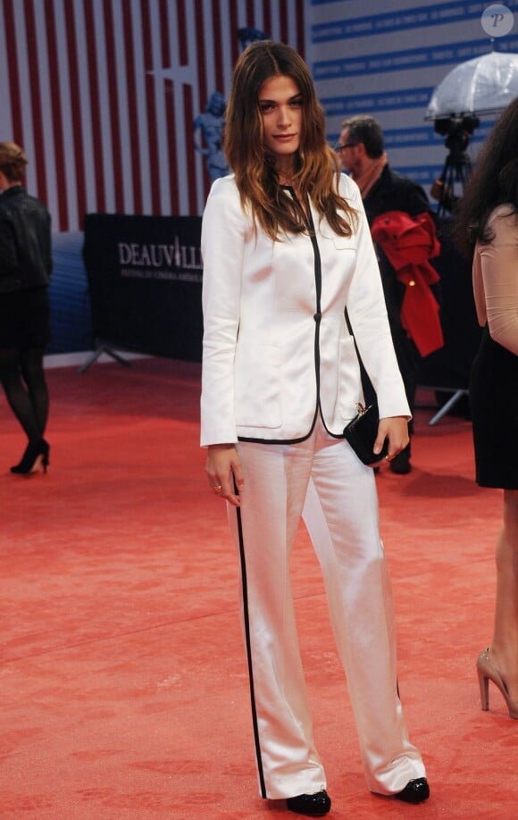 Elisa Sednaoui, stylée lors du Festival du Cinéma Américain de Deauville, foule le tapis rouge dans un ensemble blanc et noir.