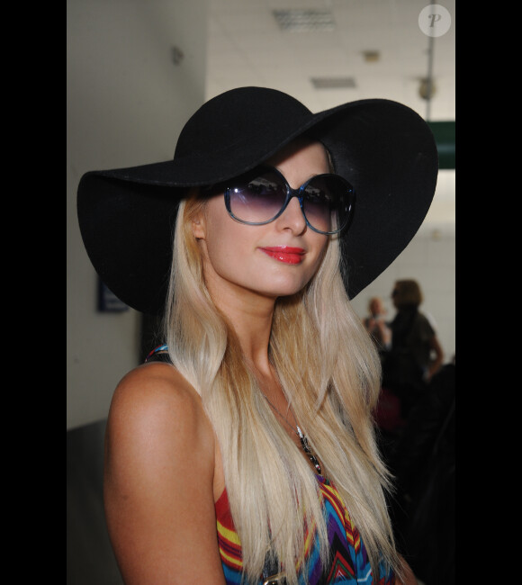 Paris Hilton, souriante, arrive à l'aéroport de Nice, le samedi 19 mai 2012.