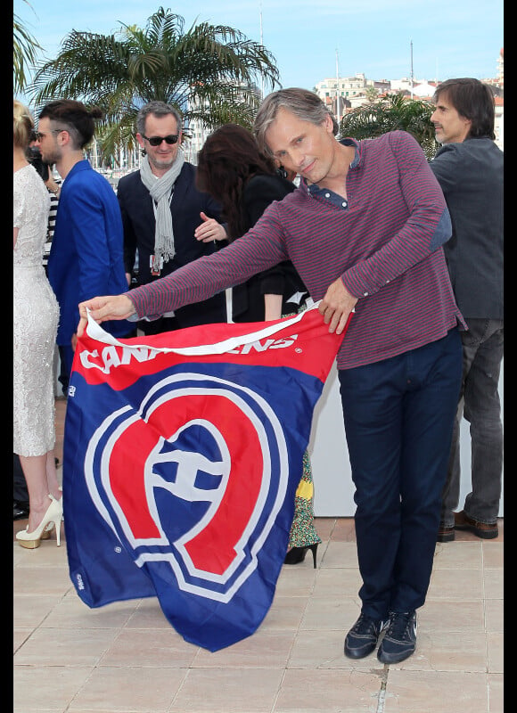 Viggo Mortensen brandit un drapeau de l'équipe de Hockey les Canadiens de Montréal lors du photocall du film Sur la route lors du Festival de Cannes le 23 mai 2012