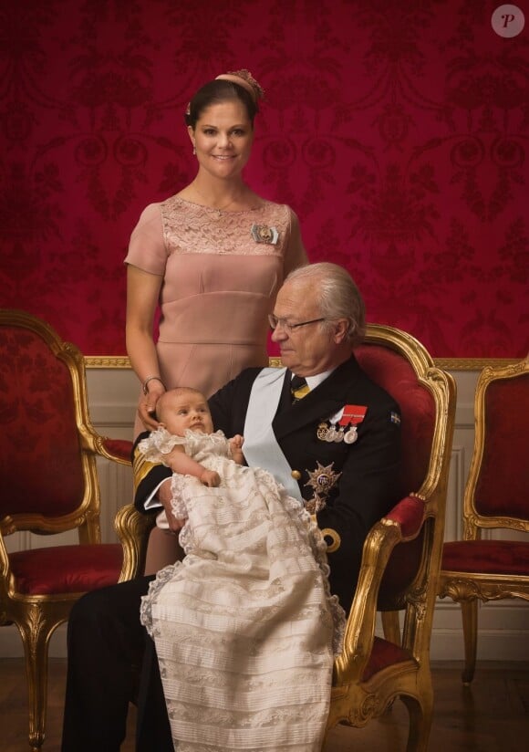 Photo de la princesse Estelle de Suède dans les bras de son grand-père le roi Carl XVI Gustaf, le 22 mai 2012, par Bruno Ehrs, après son baptême.