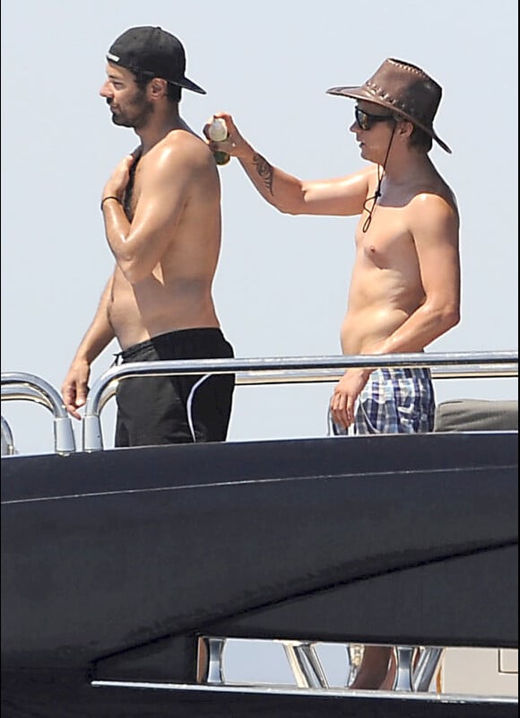 Kimi Räikkonen étale de la crème solaire à un ami, sur un yacht au large d'Ibiza, le lundi 25 juin 2012.