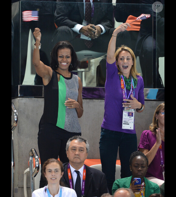 Patriote, drapeau à la main, Michelle Obama assiste aux épreuves de natation au parc aquatique, situé dans le Parc olympique à Stratford (Londres), le samedi 28 juillet 2012.