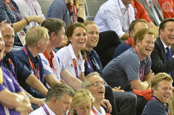 Le prince Harry dans les gradins du Vélodrome de Londres le 2 août 2012 assis aux côtés de William et Kate et du ministre David Cameron.