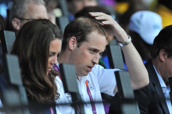 Le prince William vérifie sa coupe de cheveux au côté de sa compagne Kate le 4 août 2012 au Stade Olimpique de Londres