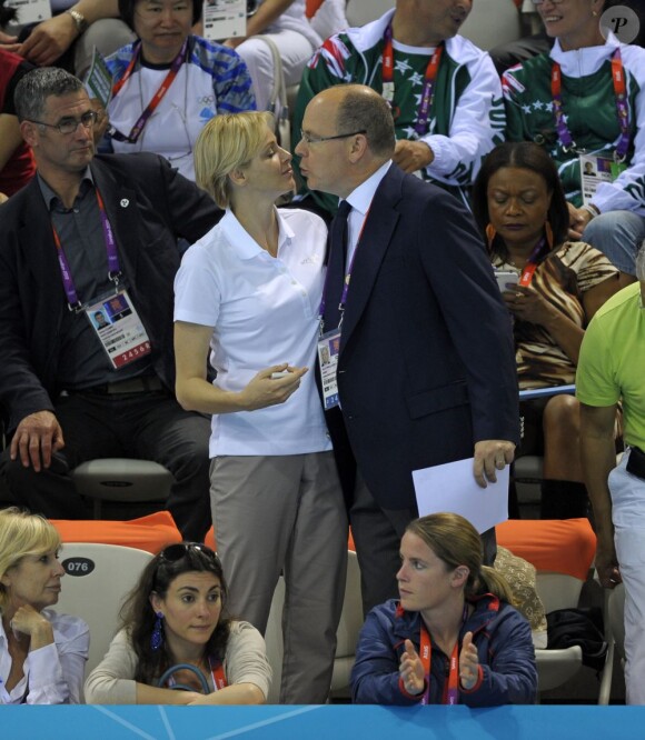 La princesse Charlene de Monaco aux Jeux olympiques de Londres 2012, à fond derrière les nageurs de l'Afrique du Sud.