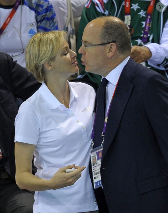La princesse Charlene de Monaco aux Jeux olympiques de Londres 2012, à fond derrière les nageurs de l'Afrique du Sud.