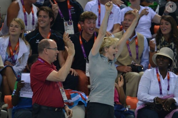 La princesse Charlene de Monaco aux Jeux olympiques de Londres 2012, à fond derrière les nageurs de l'Afrique du Sud.