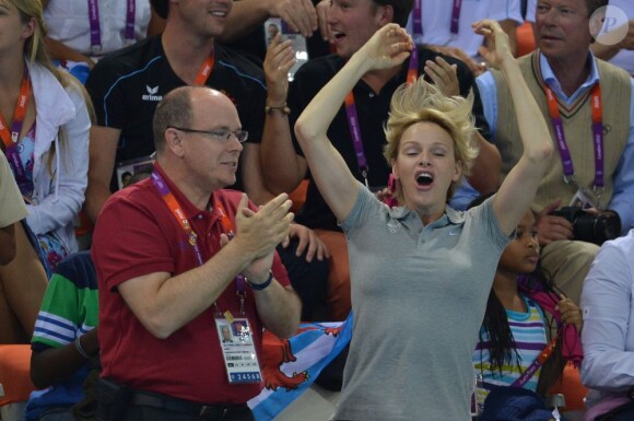 La princesse Charlene de Monaco aux Jeux olympiques de Londres 2012, à fond derrière les nageurs de l'Afrique du Sud.