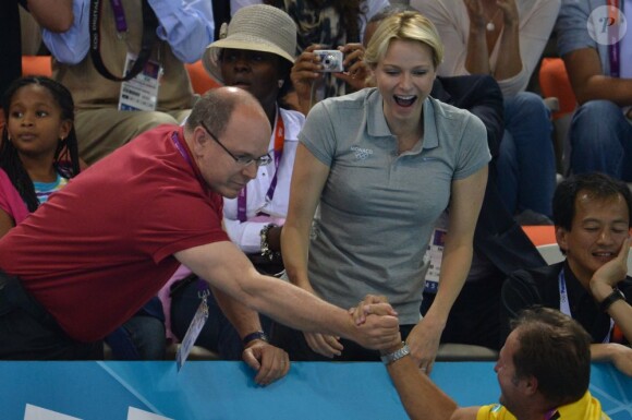 La princesse Charlene de Monaco aux Jeux olympiques de Londres 2012, à fond derrière les nageurs de l'Afrique du Sud.