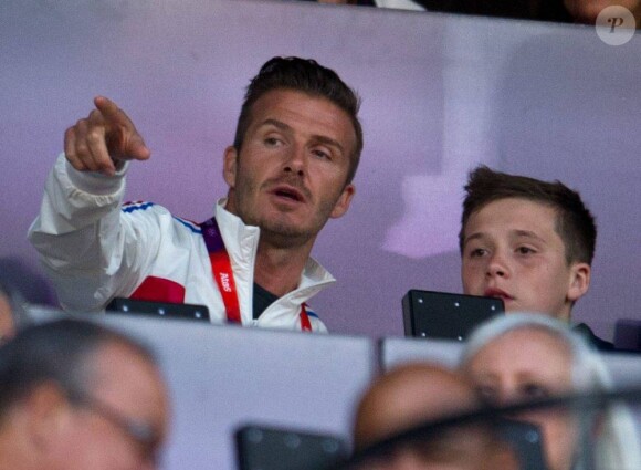 David Beckham et son fils Brooklyn suivent l'épreuve du 5 000 mètres masculin dans les tribunes du stade olympique de Londres. Le 11 août 2012.