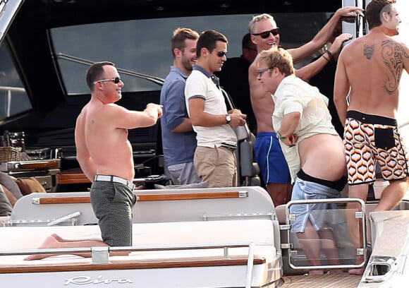Elton John, entouré d'amis sur un yacht, montre ses fesses aux photographes au large de St-Tropez, le lundi 13 août 2012.