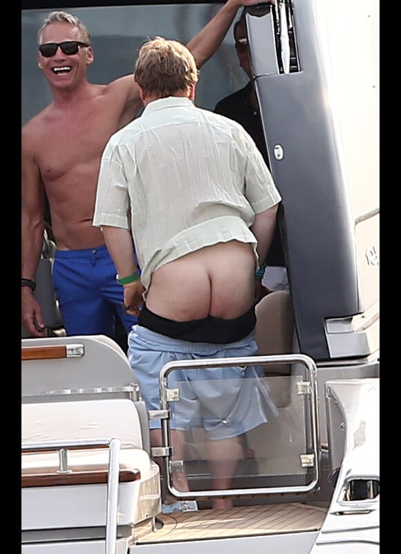 Elton John montre ses fesses aux photographes, sur un yacht au large de St-Tropez, le lundi 13 août 2012.