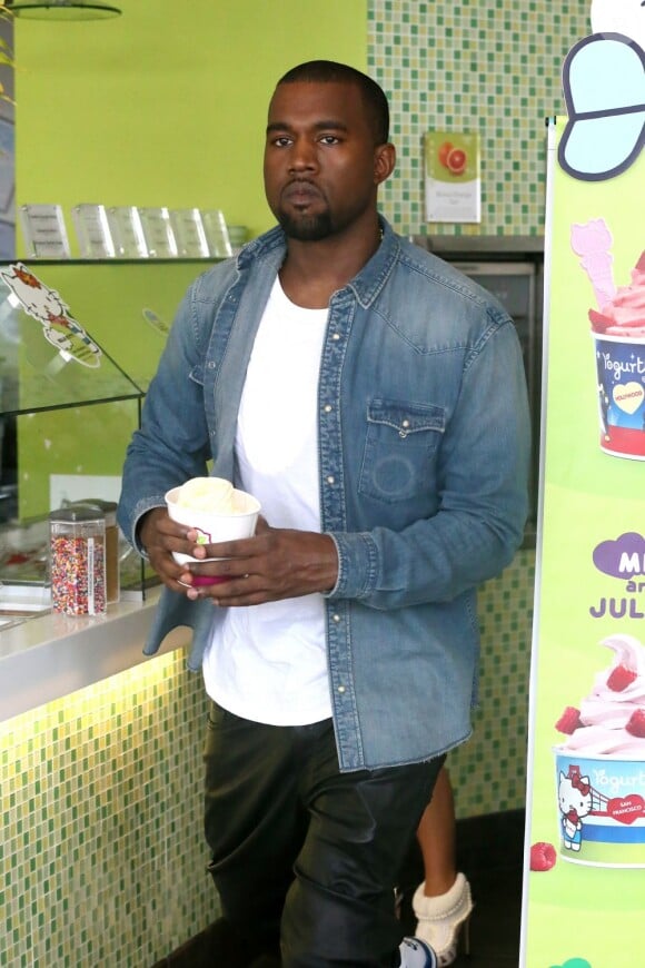 Kanye West sort de la boutique Yogurtland, un yaourt glacé entre les mains. Honolulu, le 17 août 2012.