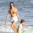 Alessandra Ambrosio ne quitte plus son short en jean blanc qu'elle porte à la plage comme sur le pavé de L.A.