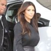 Kim Kardashian, sexy en chemise noire, jupe en cuir et sandales Tom Ford. Miami, le 16 septembre 2012.