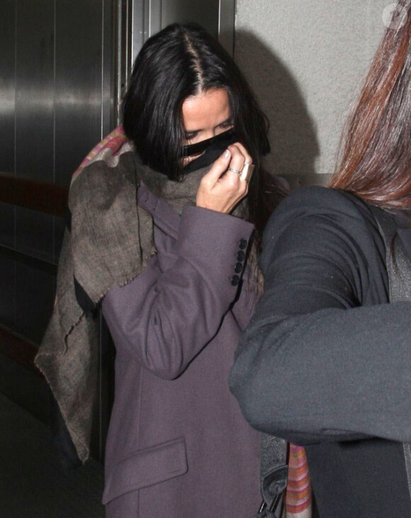 Demi Moore se cachant des photographes en arrivant a l'aéroport de Los Angeles, le 17 novembre 2012.