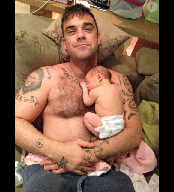 Première photo de la petite Theodora avec son papa Robbie Williams, postée sur le site officiel du chanteur, le 20 septembre 2012.