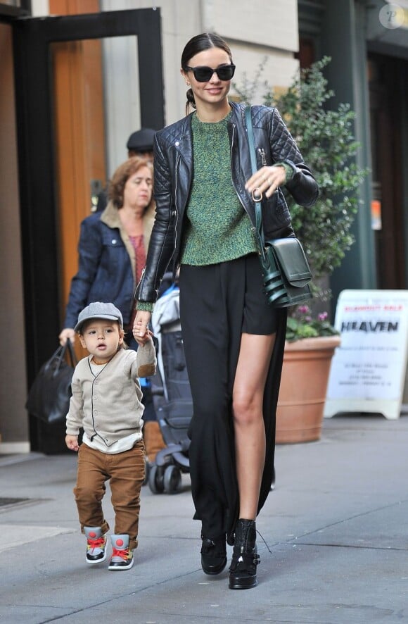 Miranda Kerr tient la main à son fils Flynn à la sortie de leur appartement, habillée d'une veste Balenciaga, d'un sweater Acne, d'une maxi-jupe noire et de bottines Tabitha Simmons. Son sac est signé Christian Louboutin. New York, le 21 novembre 2012.