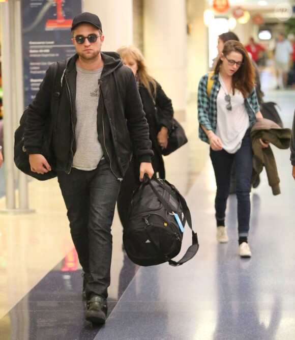 Robert Pattinson et Kristen Stewart arrivant à l'aéroport de Los Angeles le 26 Novembre 2012. Ils gardent une distance entre eux pour tenter de passer inaperçus