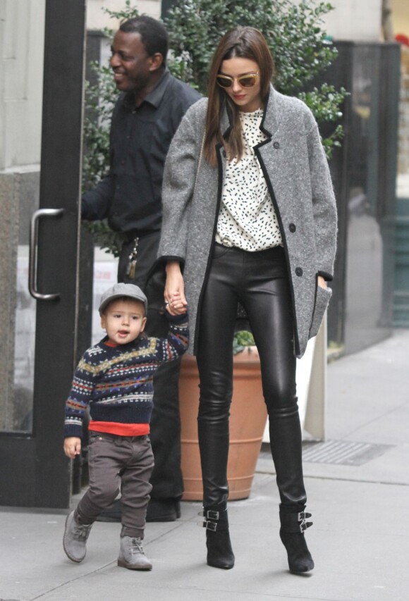 Miranda Kerr et son fils Flynn Bloom dans les rues de New York, porte des lunettes Miu Miu, un manteau Isabel Marant, un sac Valentino, un pantalon en cuir et des bottines Barbara Bui. Le 29 novembre 2012.