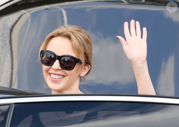 Kylie Minogue et son compagnon Andres Velencoso arrivent à Sydney, le 28 décembre 2012. Elle prend le temps de saluer ses fans.