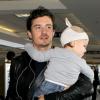 L'acteur Orlando Bloom arrive à l'aéroport de Los Angeles avec son fils Flynn dans les bras. Le 22 janvier 2013.