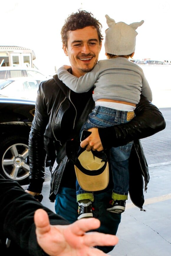 L'acteur Orlando Bloom arrive à l'aéroport de Los Angeles avec son fils Flynn dans les bras. Le 22 janvier 2013.