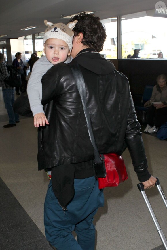 L'acteur Orlando Bloom arrive à l'aéroport de Los Angeles avec son fils Flynn, deux ans, dans les bras. Le 22 janvier 2013.