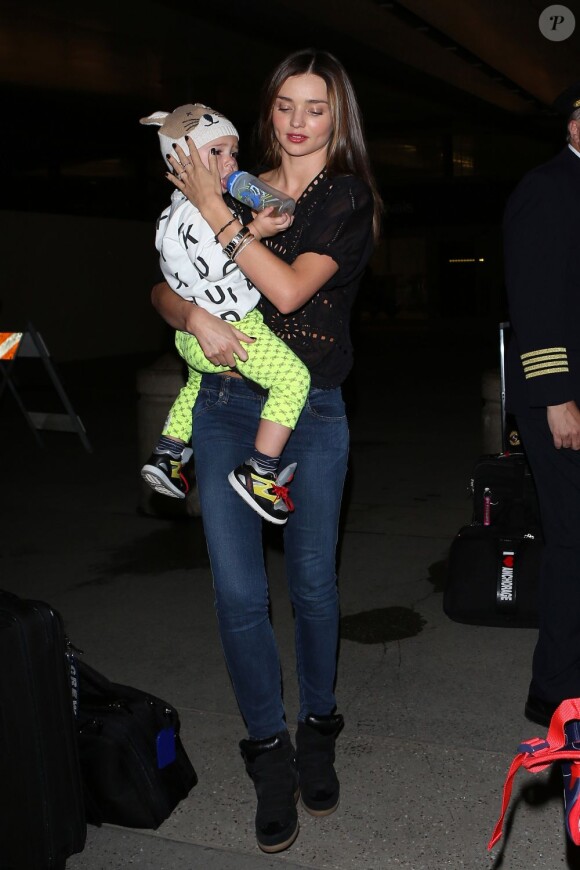 Miranda Kerr porte son fils Flynn à l'aéroport de Los Angeles, habillée d'un top et de baskets Isabel Marant. Le 26 janvier 2013.