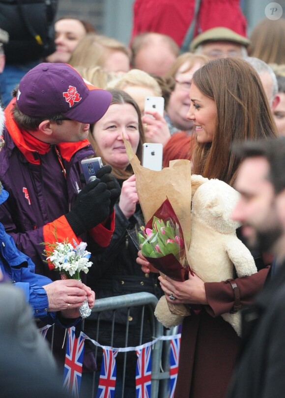 La duchesse de Cambridge, Kate Middleton reçoit un ours en peluche, en visite à Grimsby en Angleterre, le 5 mars 2013.