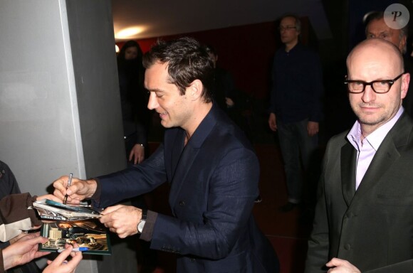 Jude Law signe des autographes au côté du réalisateur du film Steven Soderbergh pendant la première d'Effets secondaires à l'UGC Ciné Cité des Halles à Paris le 7 mars 2013.