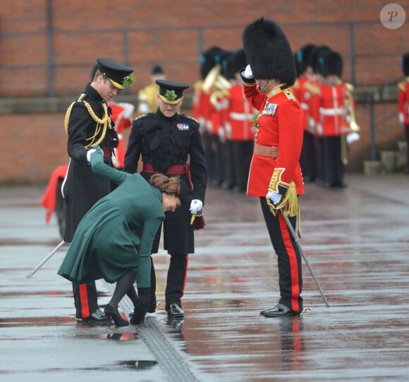 La pauvre Kate Middleton (enceinte), duchesse de Cambridge, coince le talon de l'un de ses escarpins alors qu'elle assiste auprès du prince William à la parade de la St Patrick à Mons Barracks, Aldershot, le 17 mars 2013.