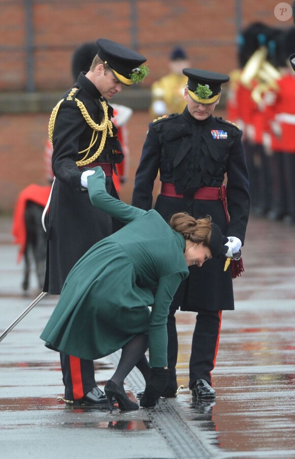 La pauvre Kate Middleton (enceinte), duchesse de Cambridge, coince le talon de l'un de ses escarpins alors qu'elle assiste auprès du prince William à la parade de la St Patrick à Mons Barracks, Aldershot, le 17 mars 2013.