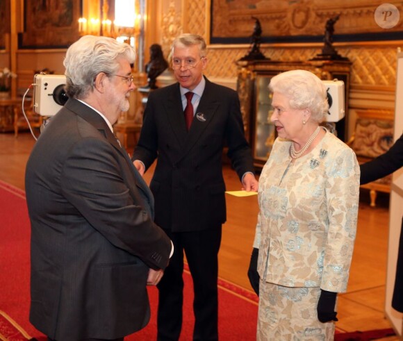 George Lucas et la reine Elisabeth II à l'occasion d'une cérémonie célébrant le cinéma britannique, au château de Windsor à Londres, le 4 avril 2013. 