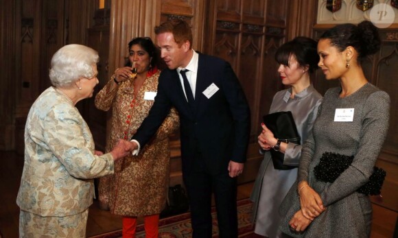 La reine Elisabeth II salue Damian Lewis, Helen McCrory et Thandie Newton à l'occasion d'une cérémonie célébrant le cinéma britannique, au château de Windsor à Londres, le 4 avril 2013. 