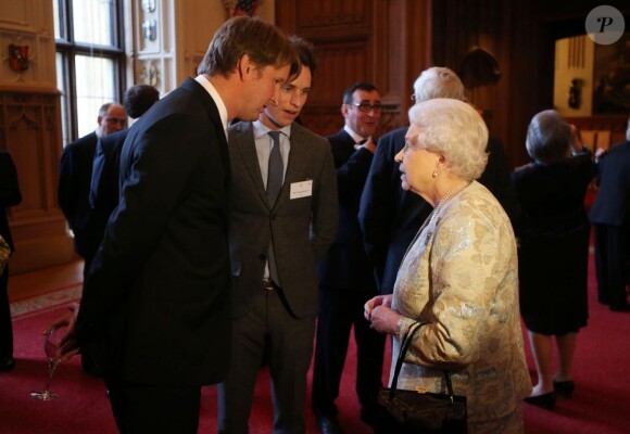 La reine Elizabeth II, Tom Hooper et Eddie Redmayne à l'occasion d'une cérémonie célébrant le cinéma britannique, au château de Windsor à Londres, le 4 avril 2013. 