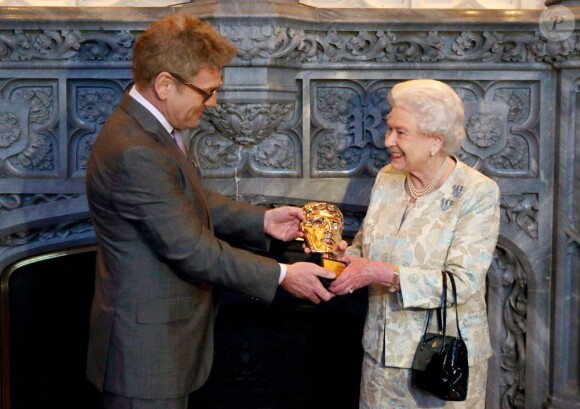 Kenneth Brangah remet à la reine Elizabeth II un BAFTA d'honneur pour son soutien à l'industrie cinématographique britannique, au château de Windsor à Londres, le 4 avril 2013. 